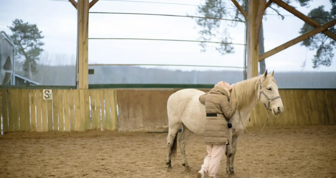 Une jeune femme étreignant un cheval lors d'un atelier d'équithérapie