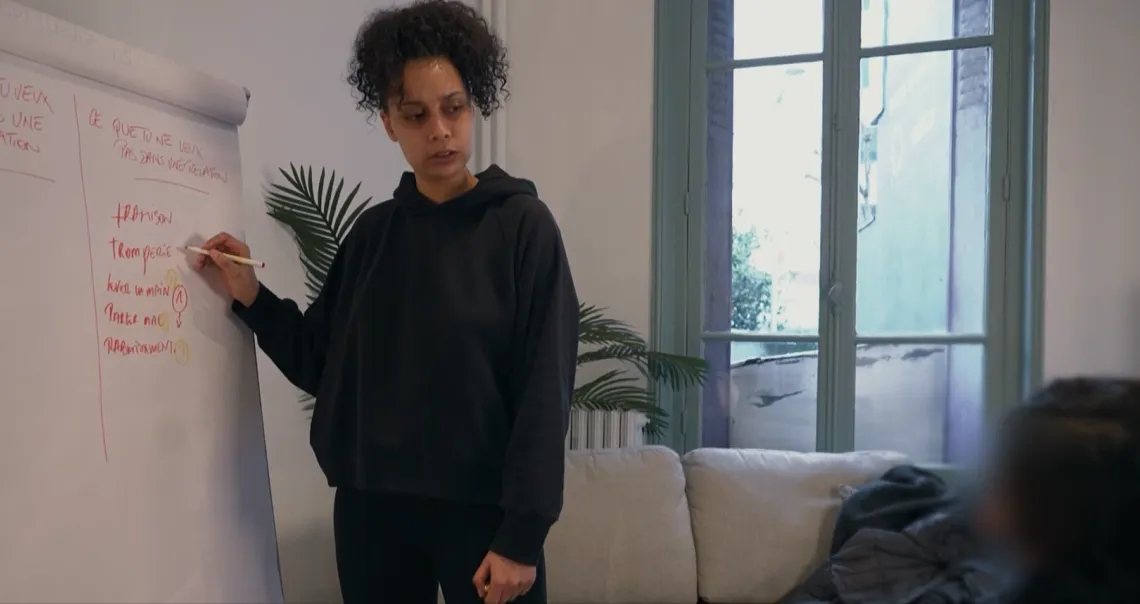 Une éducatrice écrit sur un tableau blanc une liste nommée "ce que tu ne veux pas dans une relation"