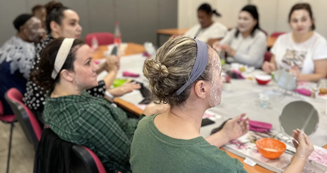 Des femmes parlent autour d'une table et de produits de beauté