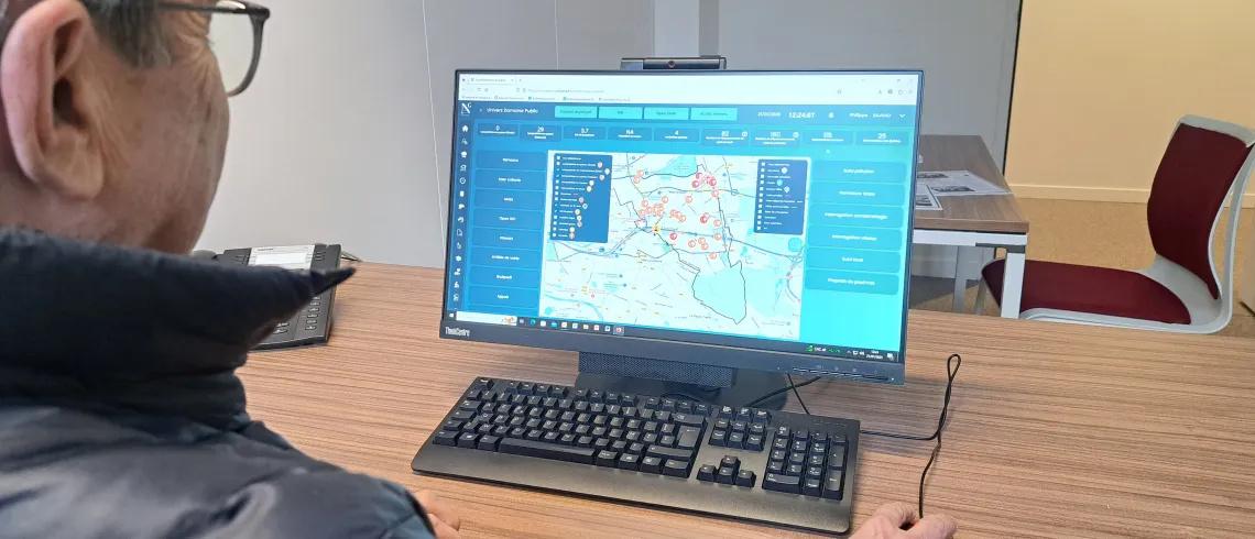 Monsieur Sajhau regarde la plateforme de données derrière son ordinateur