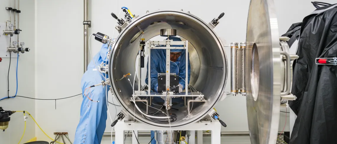 La photo présente un moteur pour un petit satellite, fabriqué par ION-X, et deux employés..