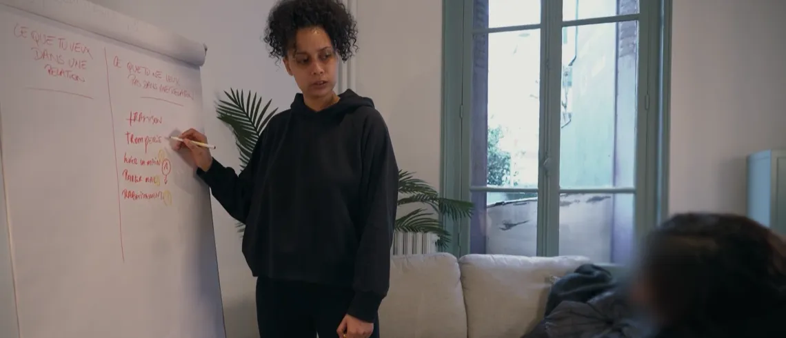 Une éducatrice écrit sur un tableau blanc une liste nommée "ce que tu ne veux pas dans une relation"